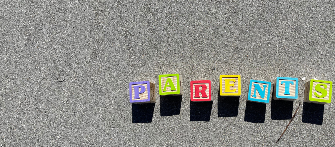 Letter blocks spelling out 'parents' in the sand.