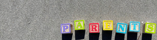 Letter blocks spelling out 'parents' in the sand.